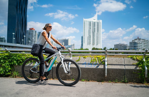 Fahrradfahrerin vor städtischer Skyline